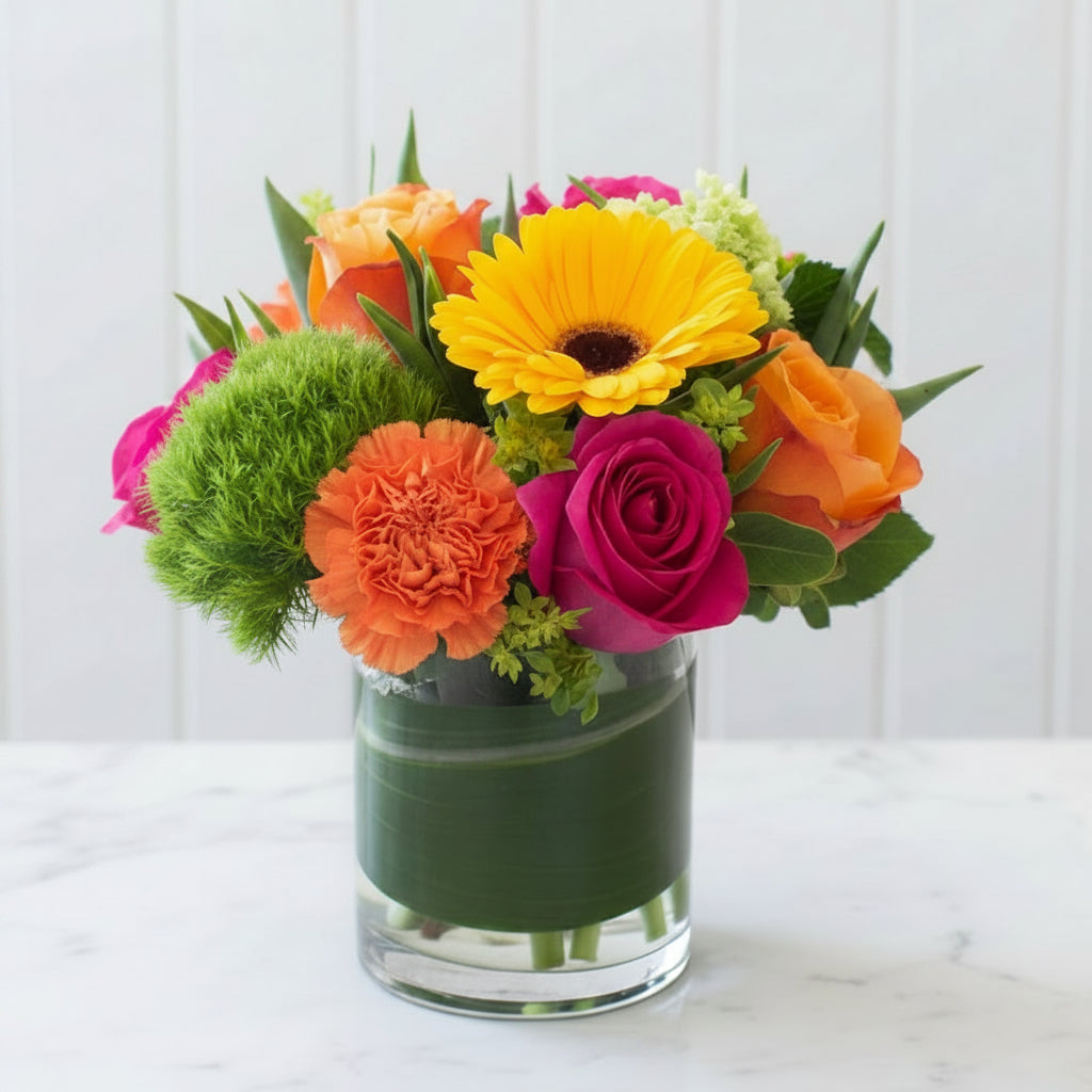 Colorful flower arrangement in a glass vase on a wooden surface