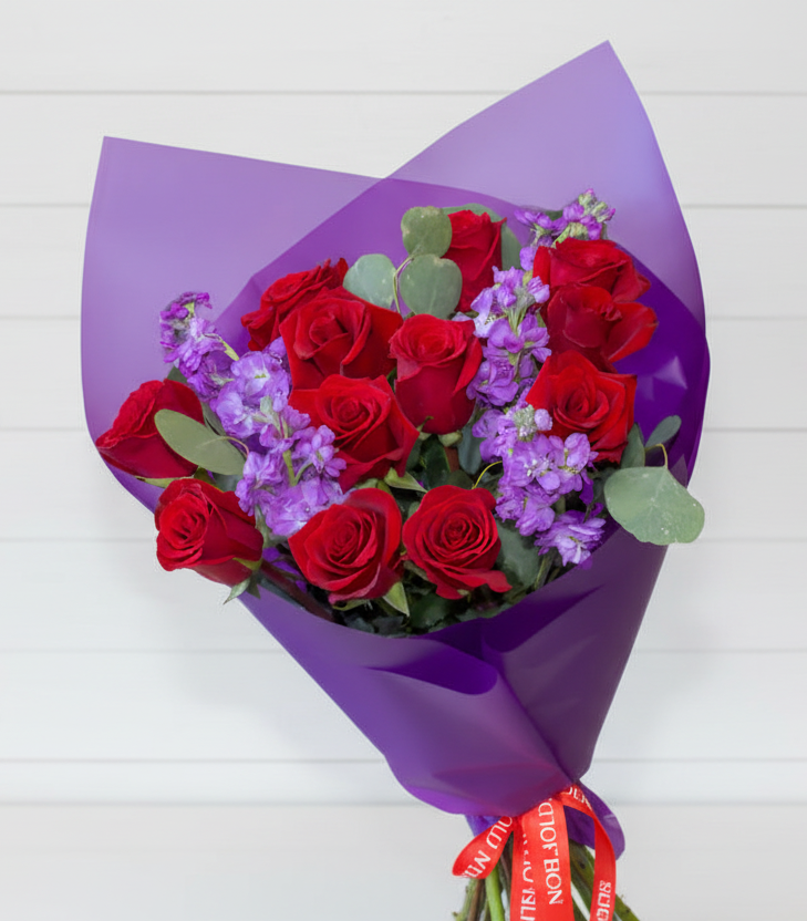 Red dozen roses with purple accents.